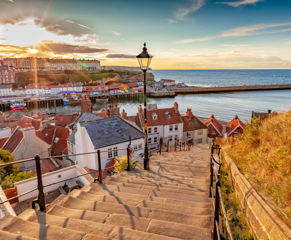 Whitby, North Yorkshire Coast, England.  Famous 199 steps at sunset over the harbour at Whitby. One of the best beach towns in Europe. 