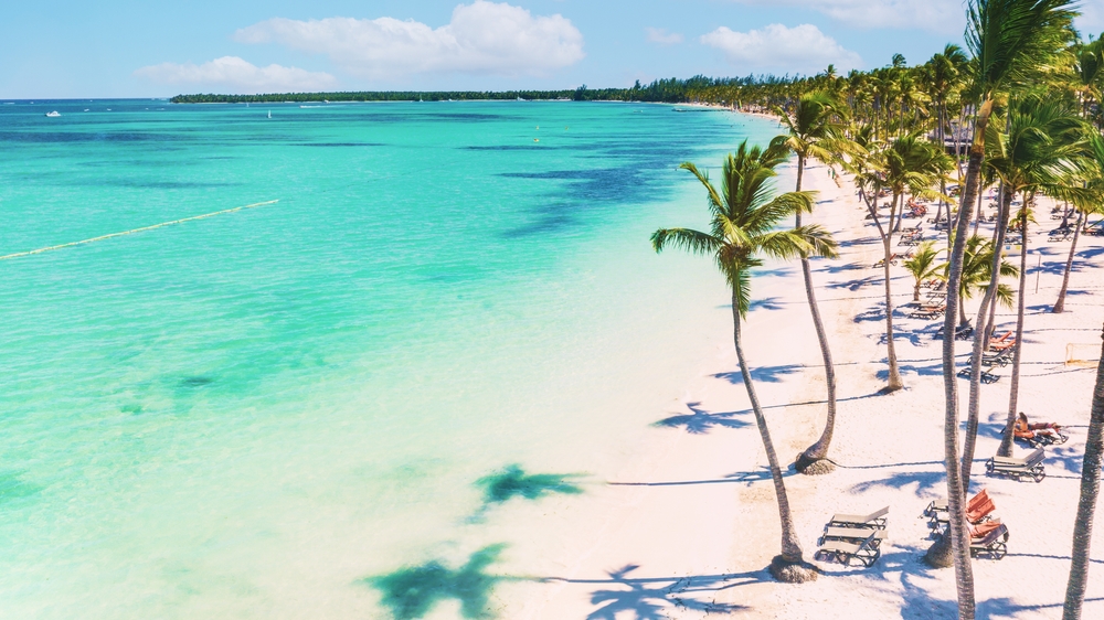 Crystal clear turquoise water, white sand, and palm trees at Bavaro, Punta Cana, Dominican Republic.