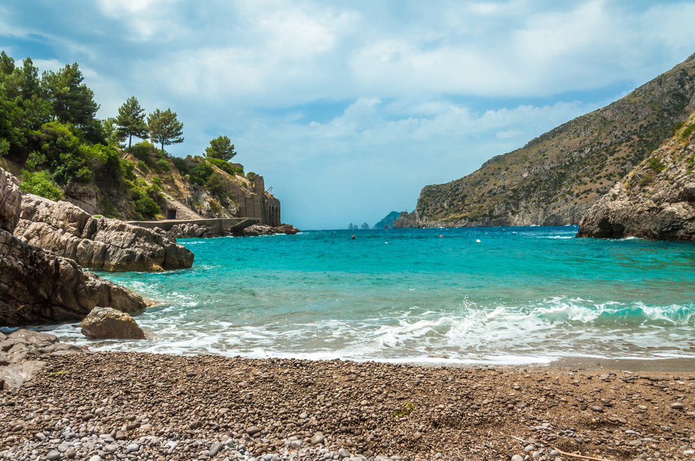 Turquoise water with pebble beach and sea int he distance