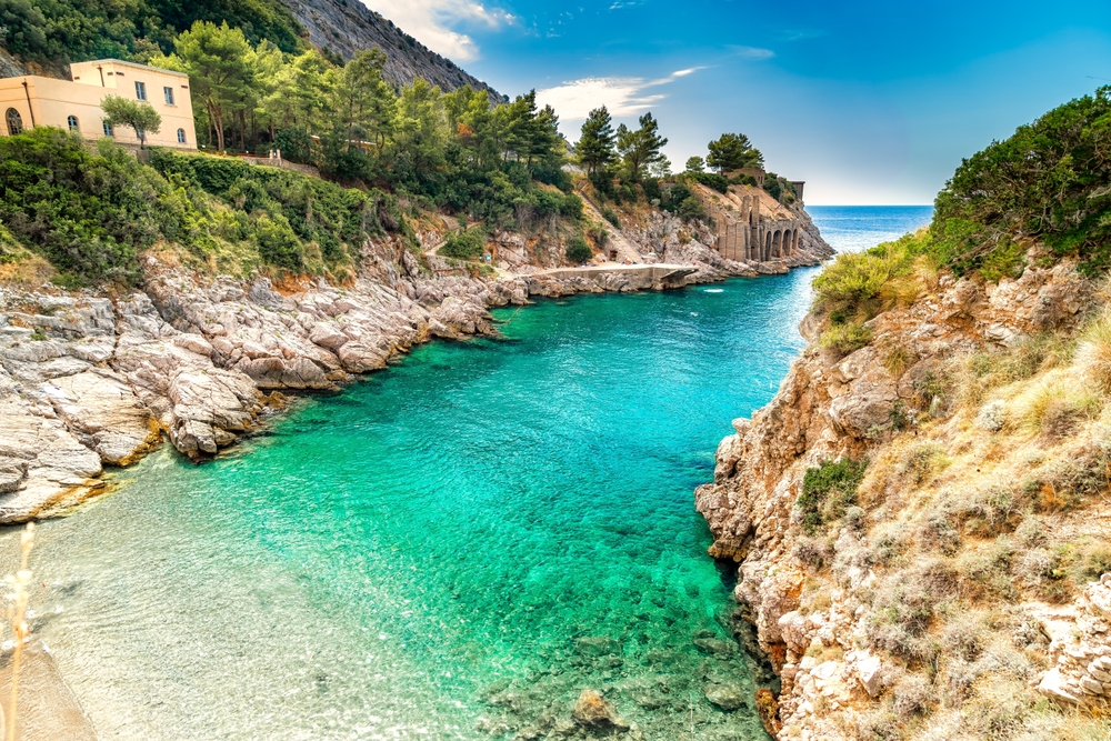 The turquoise water in the protected area of Ieranto beach a small beach surrounded by rocks on each side