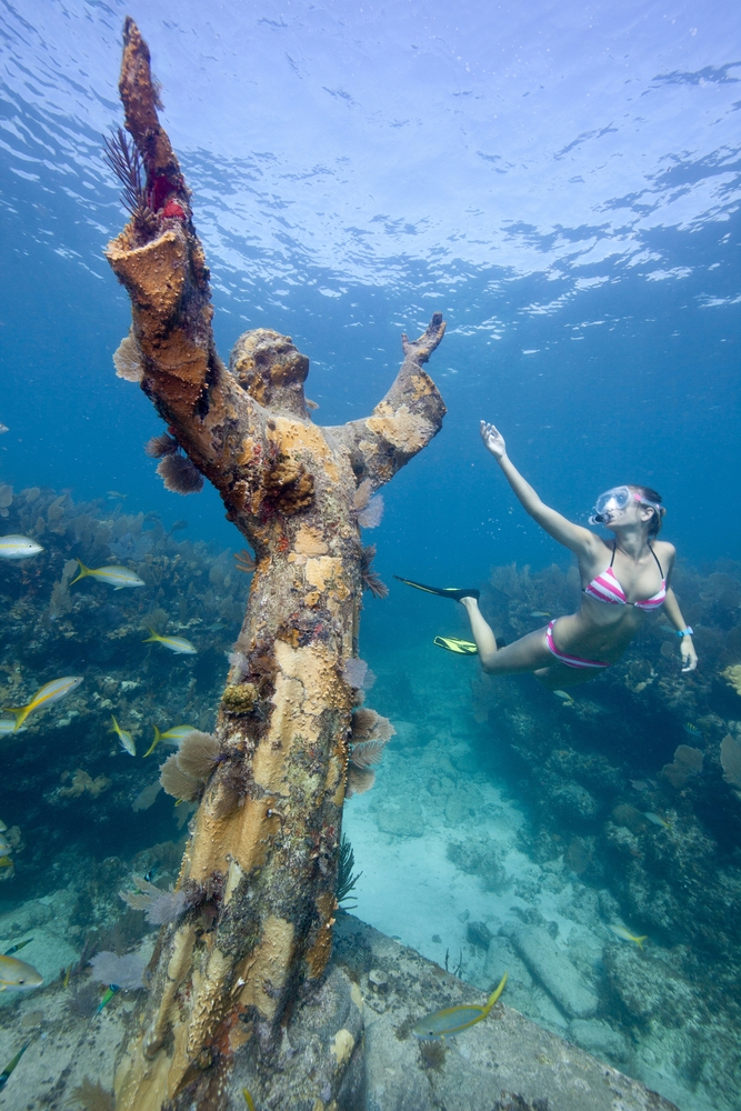 Some of the clearest water in the USA is featured at John Pennekamp State Park: even as seen in this photo, a woman snorkels near a statue with crystal clarity. 