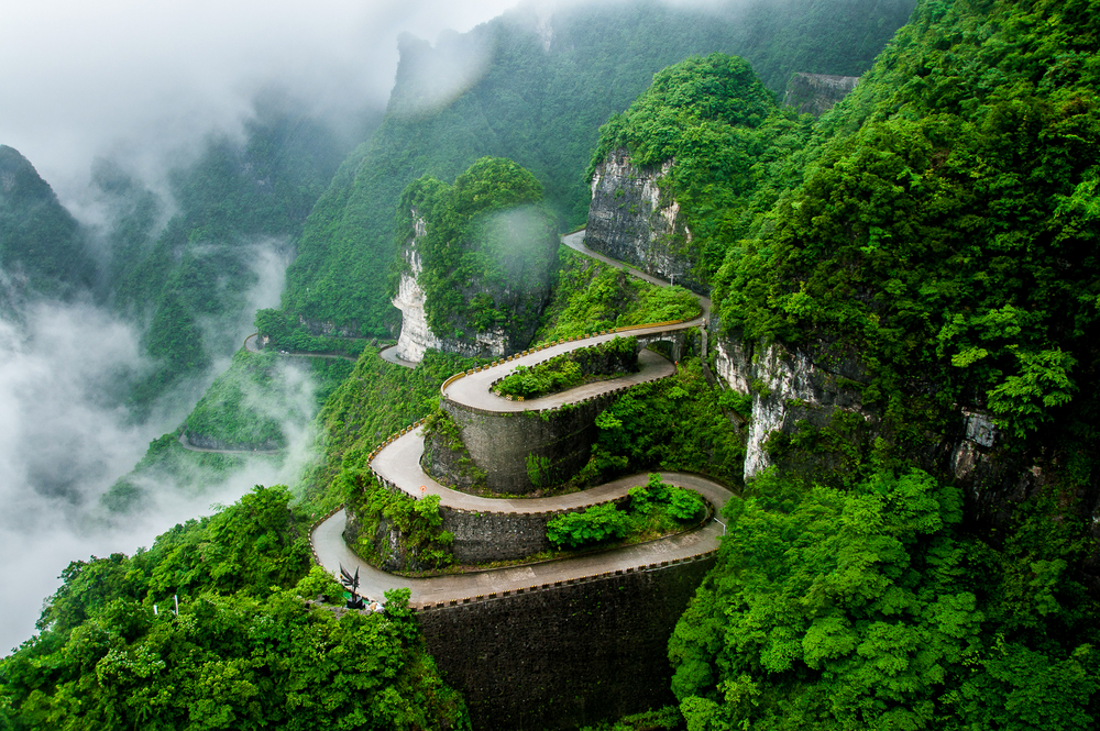 The winding road of Tianmen mountain national park (Zhangjiajie) in clouds mist, Hunan province, China. The article is about best once in a lifetime travel destinations. 