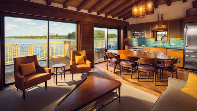 picture of inside of one of the water villas in Disney. You can see chairs and a table and a plunge pool and the lake beyond. 