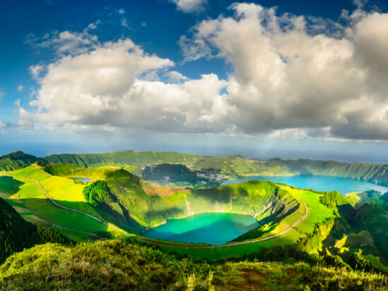 Green mountains with green lake and clouds in between