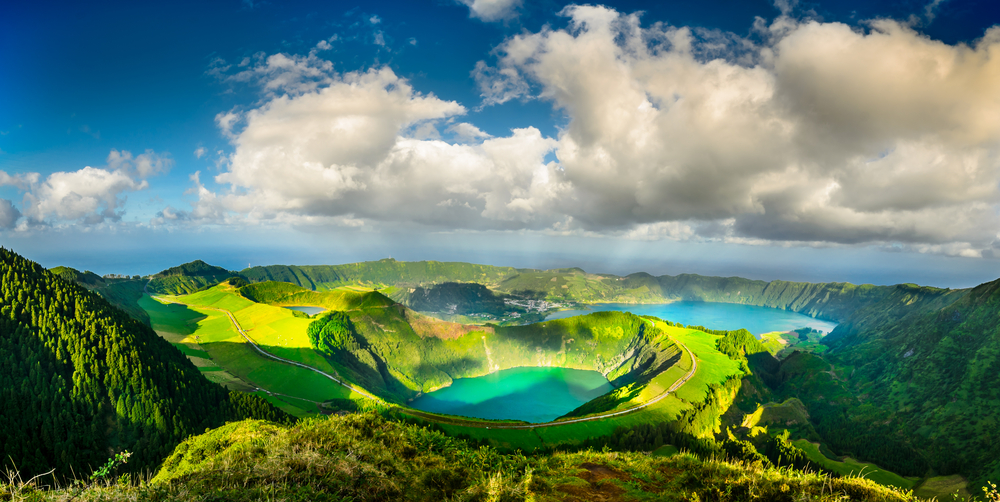 Green mountains with green lake and clouds in between