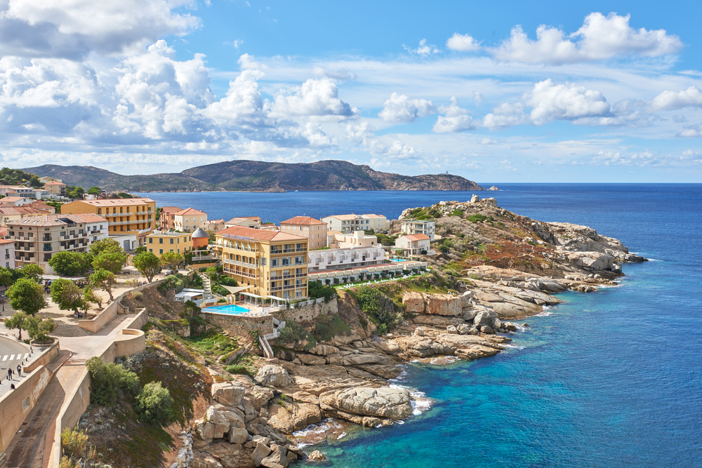 land jutting out into the ocean on the coast, there are hotels and resorts on the coastline on a cloudy day