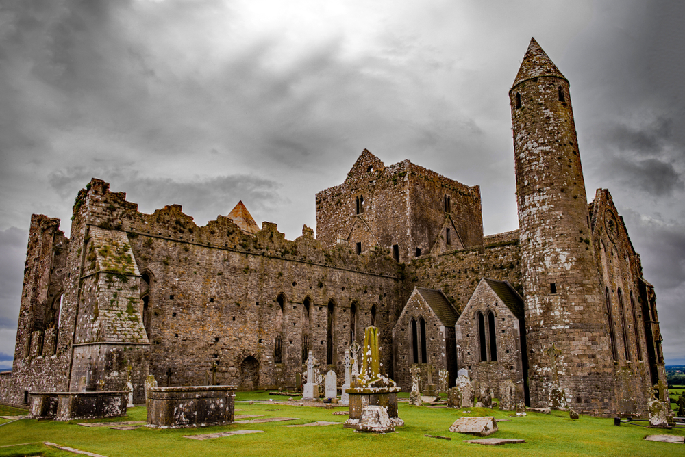 Overcast day over the stone Rock of Cashel with gravestones.