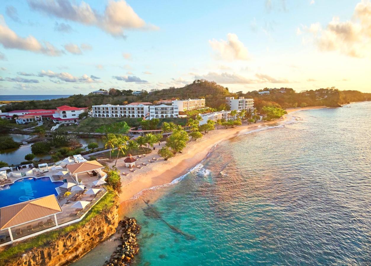 Aerial via overlooking the whole Royalton Grenada resort with the ocean on the right, view of the pool on the bottom left and the resort above. 