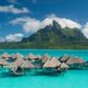 overwater bunglaows in pretty blue water in bora bora with mountains