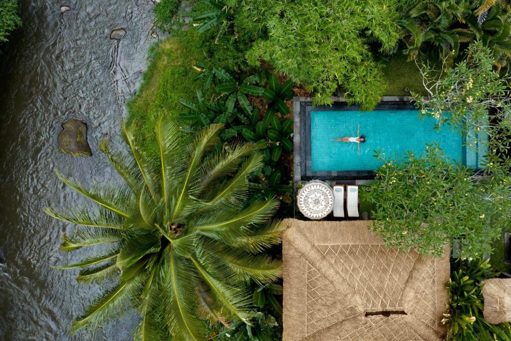 Article about the best Marriott hotels in the world. The picture shows a women in a private pool surrounded by greenery in front of a river/