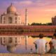 couple sitting in front of the taj mahal in india