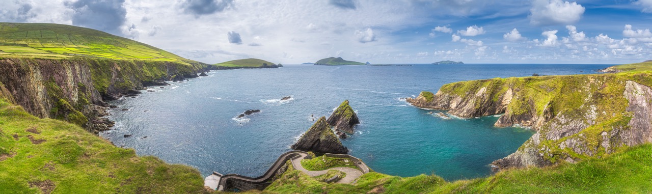 Beautiful panoramic shot of amazing Dunquin Pier and harbour with tall cliffs, turquoise water and islands, Dingle, Wild Atlantic Way, Kerry, Ireland 
