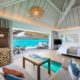 living room and bedroom with a large open dorrwar to a balcony. It is one of the Overwater Bungalows with Glass Floors