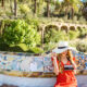 A blonde woman in a huge straw hat and red dress knows exactly what to wear in Spain.