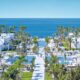 various hotel pools in a complex with palm trees all around and hotel rooms in various places . One of the best all-inclusive resorts in Europe