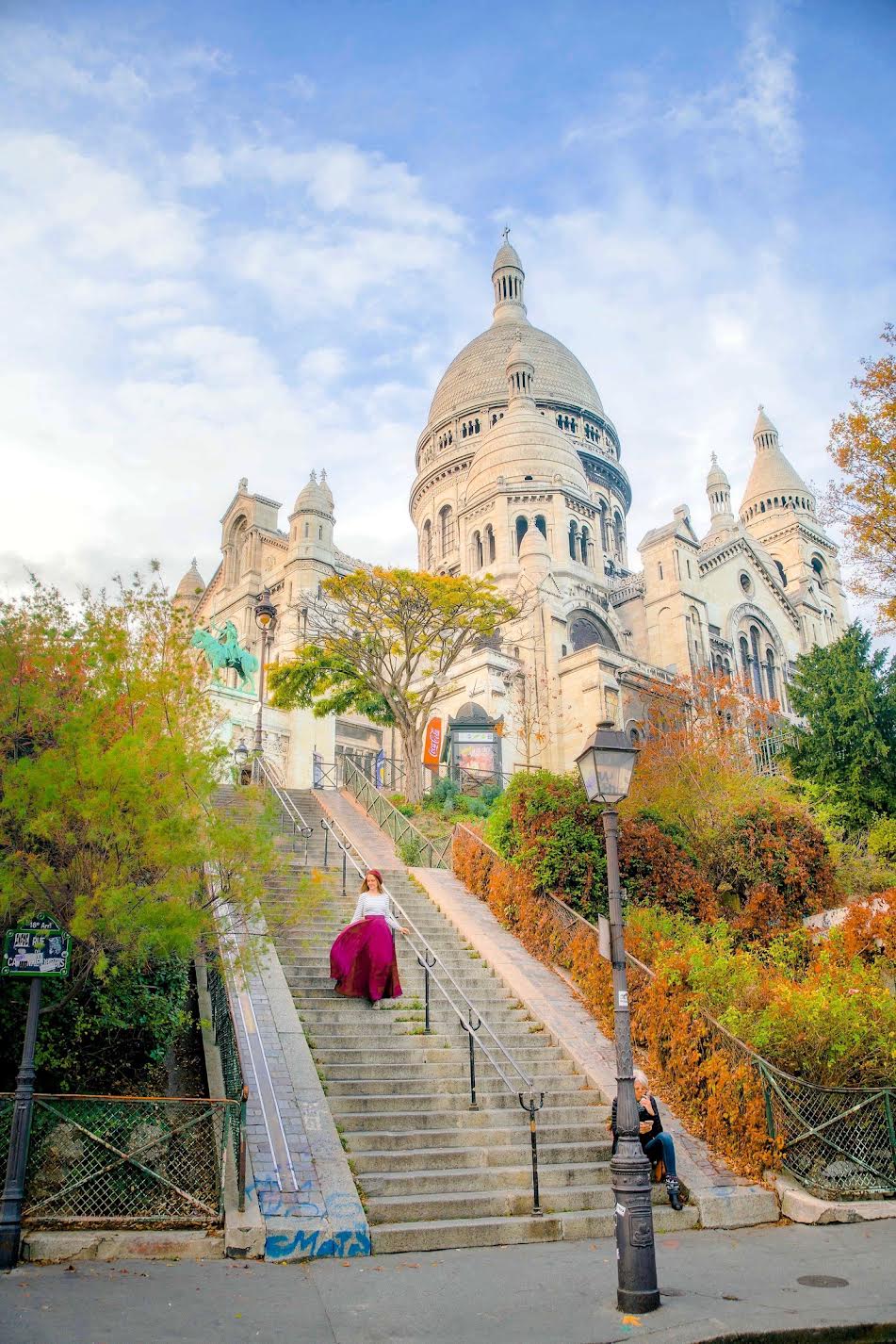 A girl in a maroon skirt carefully walks down the stairs by Note Dame, knowing mistakes to avoid in Paris!