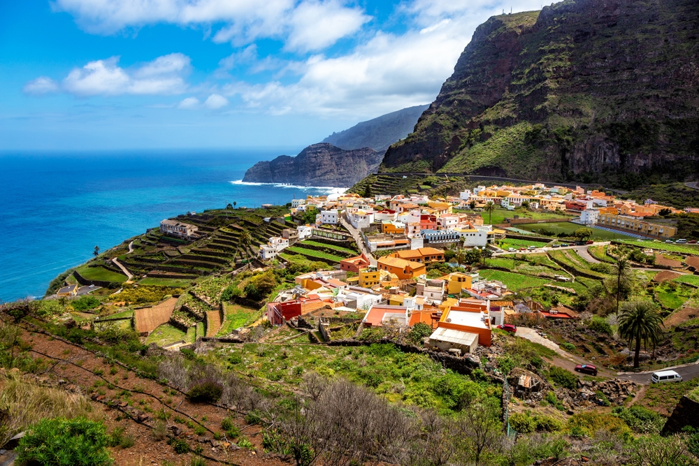 An overhead shot shows a more rural town with orange buildings right on the green coast of the waters, and you can see places like this when you know what mistakes to avoid in Spain.