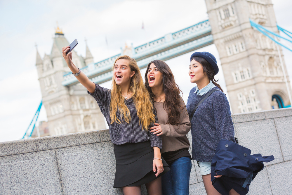Three girls taking a selfie in front of Tower Bridge