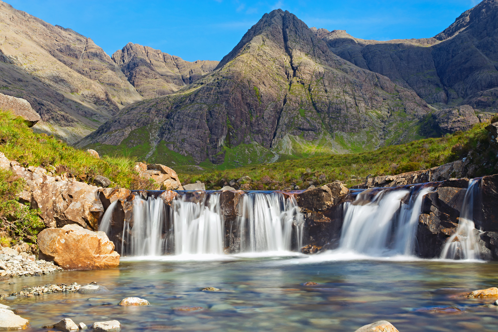 The beautiful Fairy Pools on the Isle of Skye with mountains in the background. The article is about Scotland mistakes to avoid.