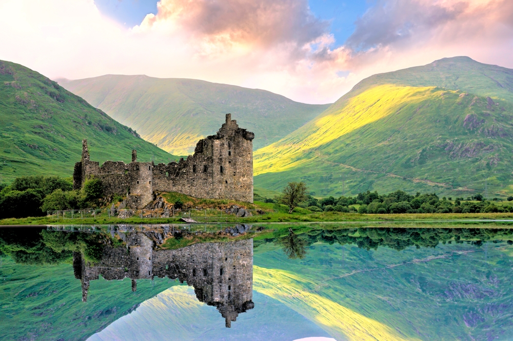 Beautiful Kilchurn Castle on Lock Awe in the highlands of Scotland at sunset with reflections. The article is about Scotland mistakes to avoid.