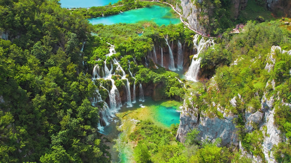 The turquoise waterfalls and pools at Plitvice Lakes national park from Ariel view with several waterfalls and forests in view