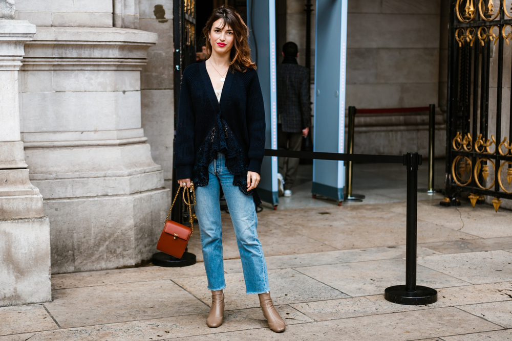 In straight leg jeans, a red lip, and lace, heavy, black cardigan, this girl knows What to wear to Paris in November.