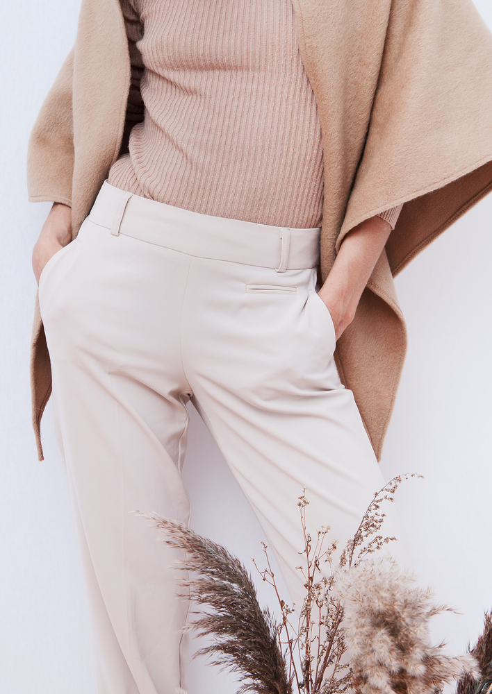 A close up of tailored pants, a ribbed shirt and wool poncho is the perfect combo to consider when wondering What to wear to Paris in November .