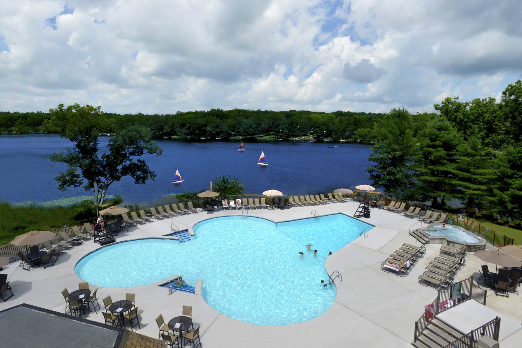 Swimming pool by a lake on a resort. This article is about best all-inclusive resorts for families in the USA