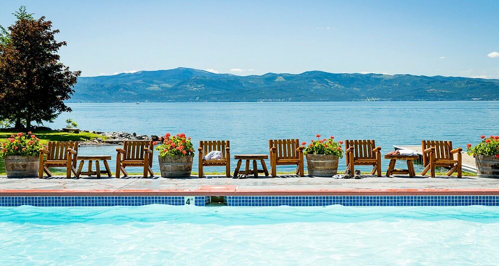 swimming pool overlooking the lake with mountains in the background. This article is about best all-inclusive resorts for families in the USA