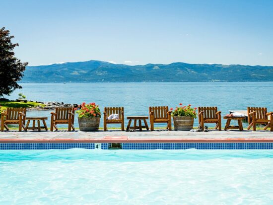 swimming pool overlooking the lake with mountains in the background. This article is about best all-inclusive resorts for families in the USA