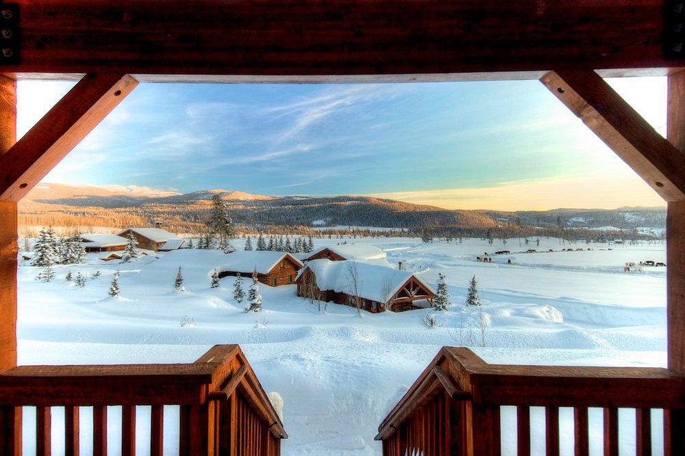 Resort in the snow as seen from a balcony of a cabin.
