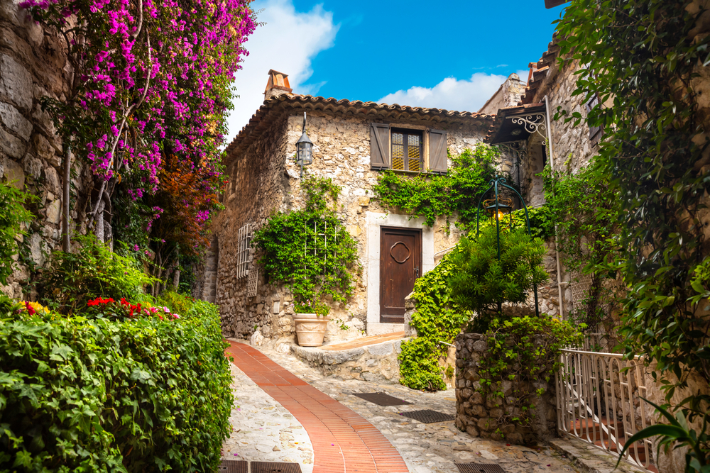 the stone village and windy cobblestone streets of this small fairytale town of Eze France with bougainvillea blooming