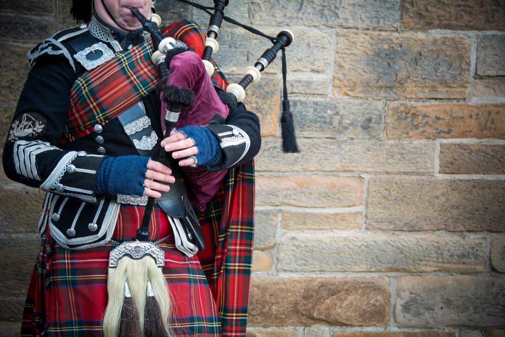 a man playing bag pipes in Edinburgh