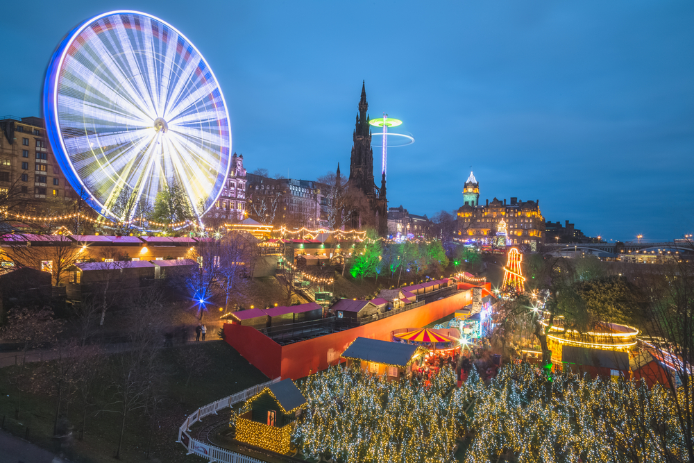 The city of Edinburgh lite up for Christmas time celebration with lights and ferris wheel and Christmas market at night