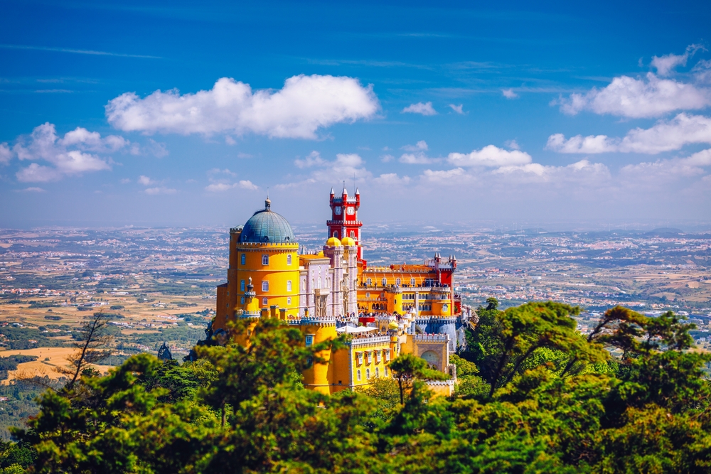 The neon colored Pena Palace sits high above the skyline in Portugal