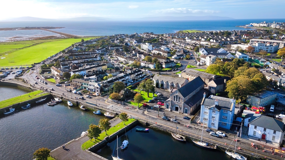 An overhead shot shows a town of Ireland: all the tall buildings, stone churches, docks on the water, and greens outside the city line. You can see this with ease when you know things to buy from Amazon for Ireland.