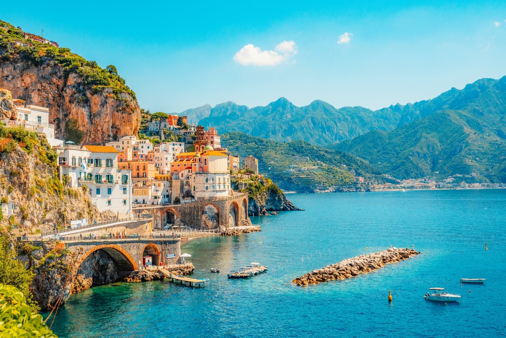 A long shot shows the coast of Italy and the island vibes with all the orange roof buildings and stones: knowing how to get here gets easier when you know what things to buy from Amazon for Italy.