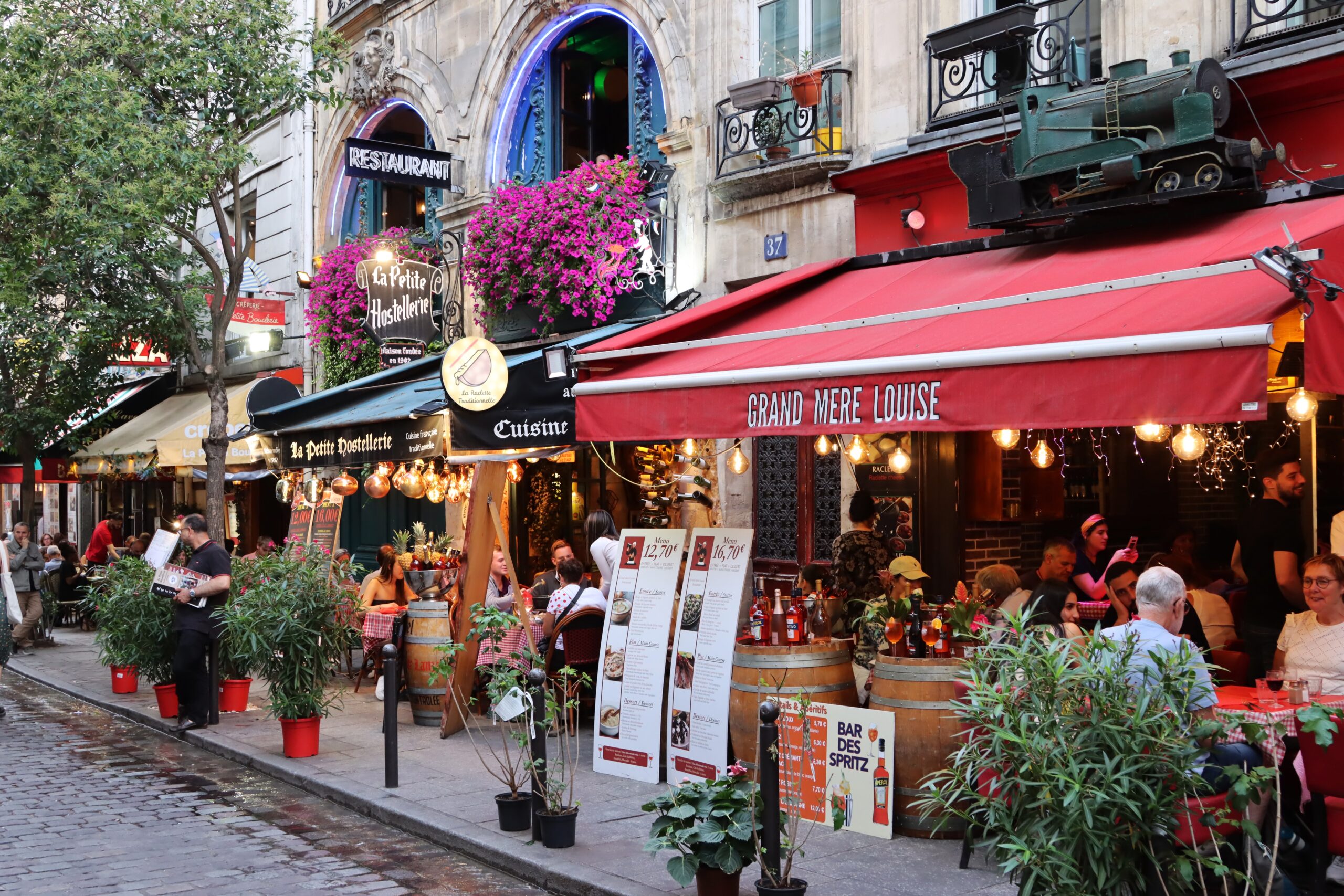 Locals and tourists gather at the restaurants that line the cobblestone streets, their bright awnings and plants and tables beckoning people in to sit and eat.