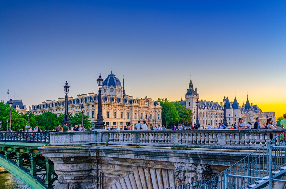 At sunrise, a bridge across the Paris Seine is busy with guests walking to and from the other areas of the city, knowing that the things to buy from Amazon for Paris will help them.