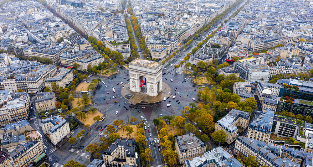 An overhead shot shows the famous roundabout and arc in Paris as cars circle around it: knowing how to navigate things like this can come from a guide book, which is one of the many things to buy from Amazon for Paris.