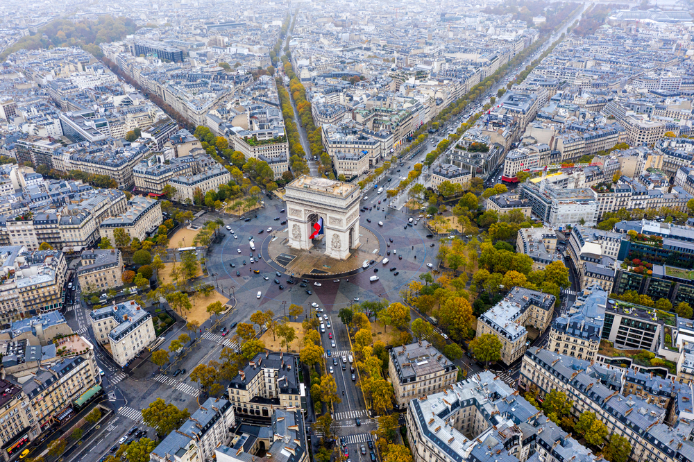 A shot overhead shows the city of Paris around the famous roundabout, cars circling and leading to side streets of neighborhoods and other areas: knowing how to navigate this is a part of things to buy from Amazon for Paris, and it becomes easier when. you buy things like maps!