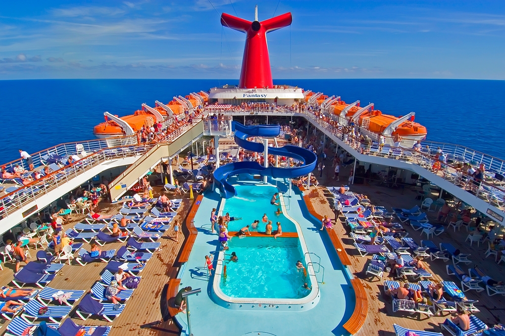 A shot of a buys pool deck with slides, guests, and deck levels shows how fun a cruise can be! 
