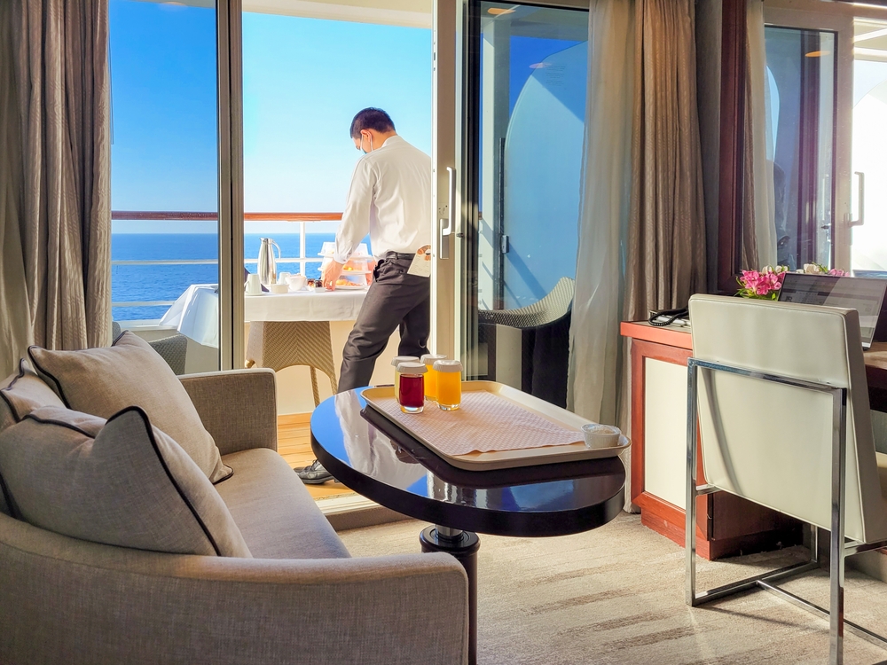 A guest prepares a deckside dinner option in a cruise room, and from the look of the chairs and room, you can tell guests knew what things to buy from Amazon for a cruise, as it isn't cluttered.