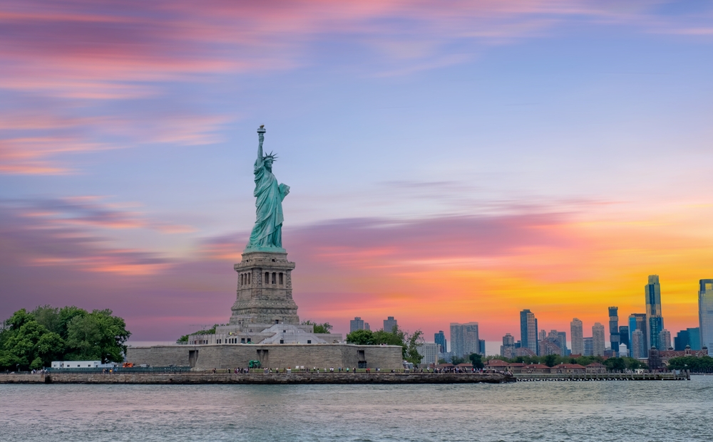 Statue of Liberty New York and Manhattan at sunset.