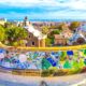 Barcelona city panoramic view of Parc Guell with colorful tiles overlook the city beneath it. The article is about things to buy from Amazon before going to Spain.