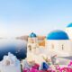 Traditional greek village Oia of Santorini, with blue domes against sea and caldera, Greece, web banner format. Article is about things to buy from Amazon for Greece.