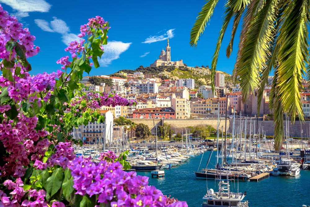A sea-side city with boats, and orange-hued buildings show a tropical yet European vibe of a vacation, and knowing this helps know what things to buy from amazon for vacation.