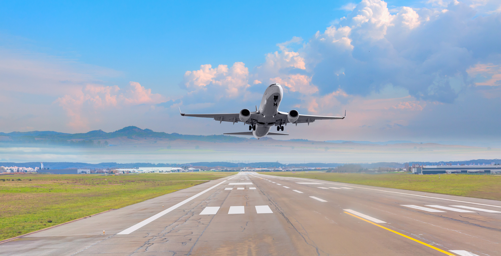When knowing what things to buy from Amazon before flying, flights are easy, as seen in this photo as a plane takes off the runway, pink skies behind it.