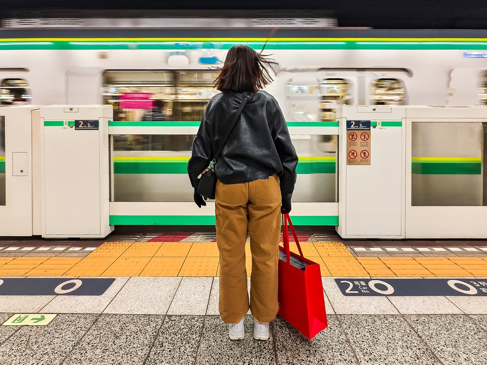A woman in yellow pants and a leather jacket faces the public transport of Japan, ready to ride.