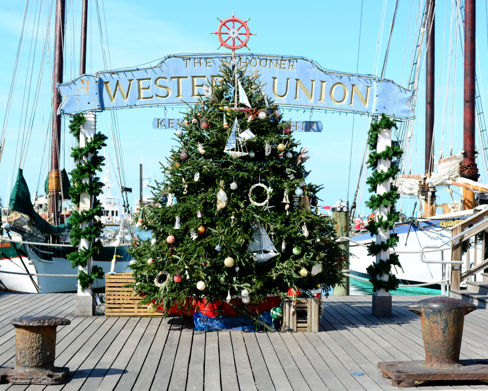 Key West, Florida, offers a beach holiday welcome with a huge Christmas tree on a dock by ships, making it known that this is one of the Best Places to Celebrate Christmas on The Beach.